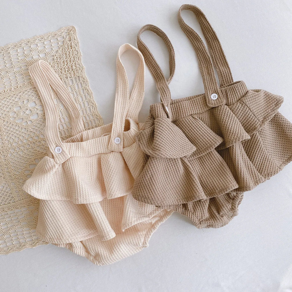 Baby girl in a pleated lotus leaf style cotton romper, triangle climb suit design for 0-2 year olds.
