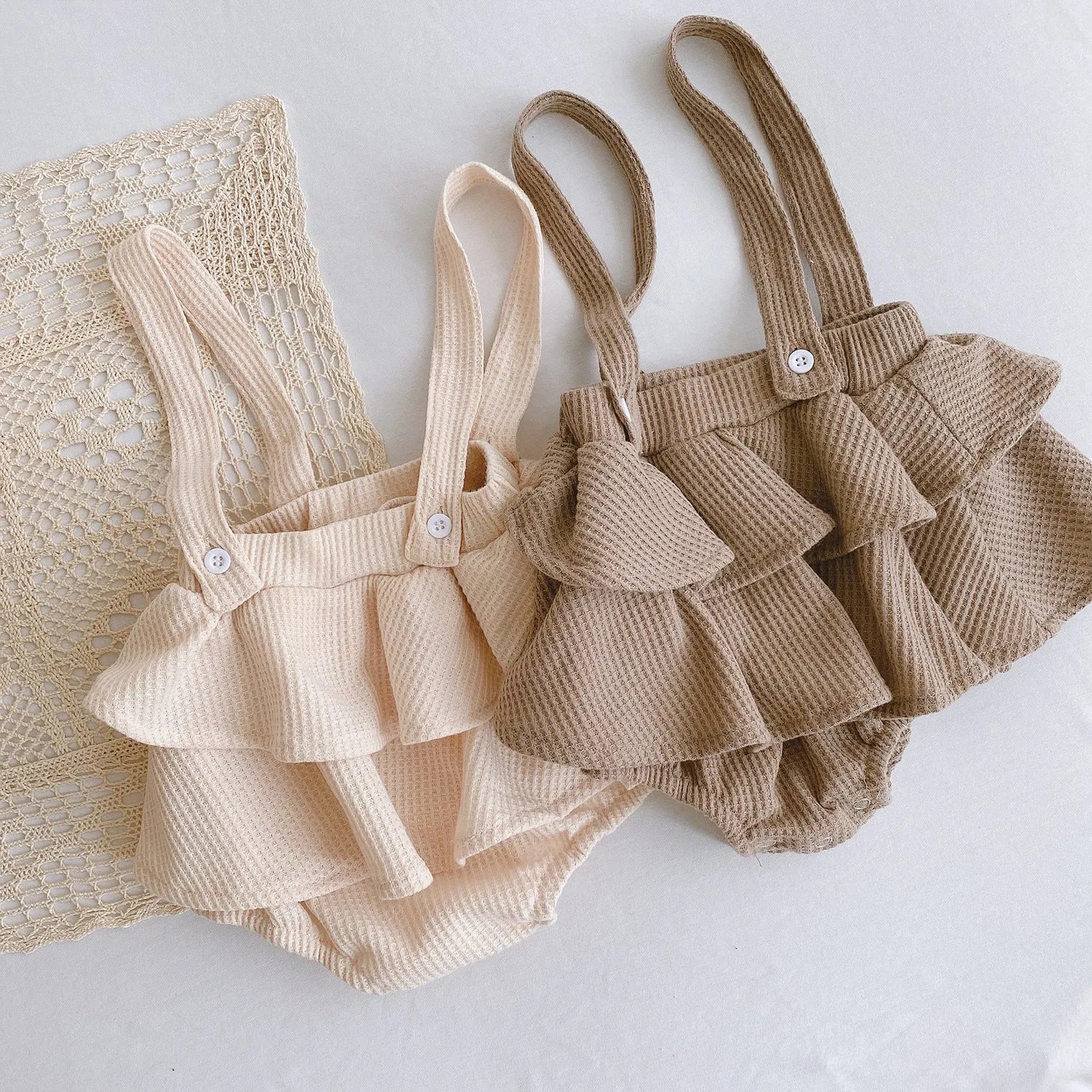 Baby girl in a pleated lotus leaf style cotton romper, triangle climb suit design for 0-2 year olds.