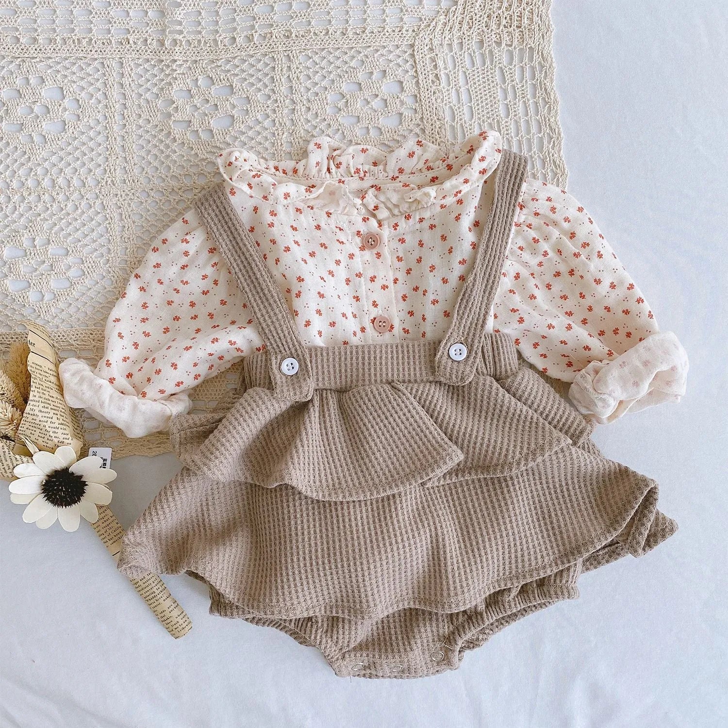 Baby girl in a pleated lotus leaf style cotton romper, triangle climb suit design for 0-2 year olds.