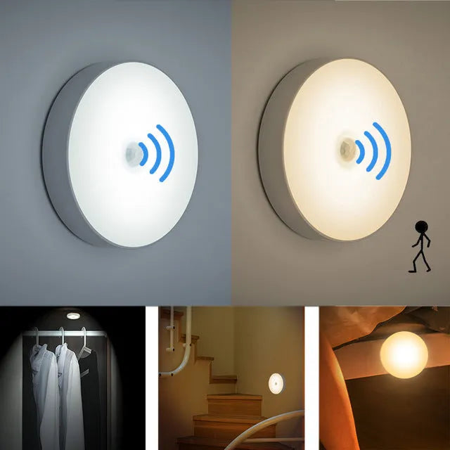 Compact white LED motion sensor night light with USB charging cable on a dark surface.
