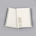 Creative coil-bound notebook open showing grid dot matrix pages, with PP matte cover in A5 size.