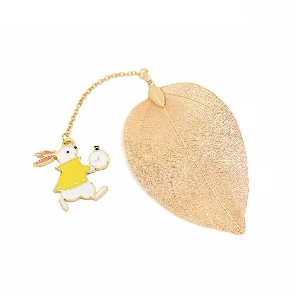 Set of three metal bookmarks featuring Alice, a rabbit, and a clock charm on a leaf base.