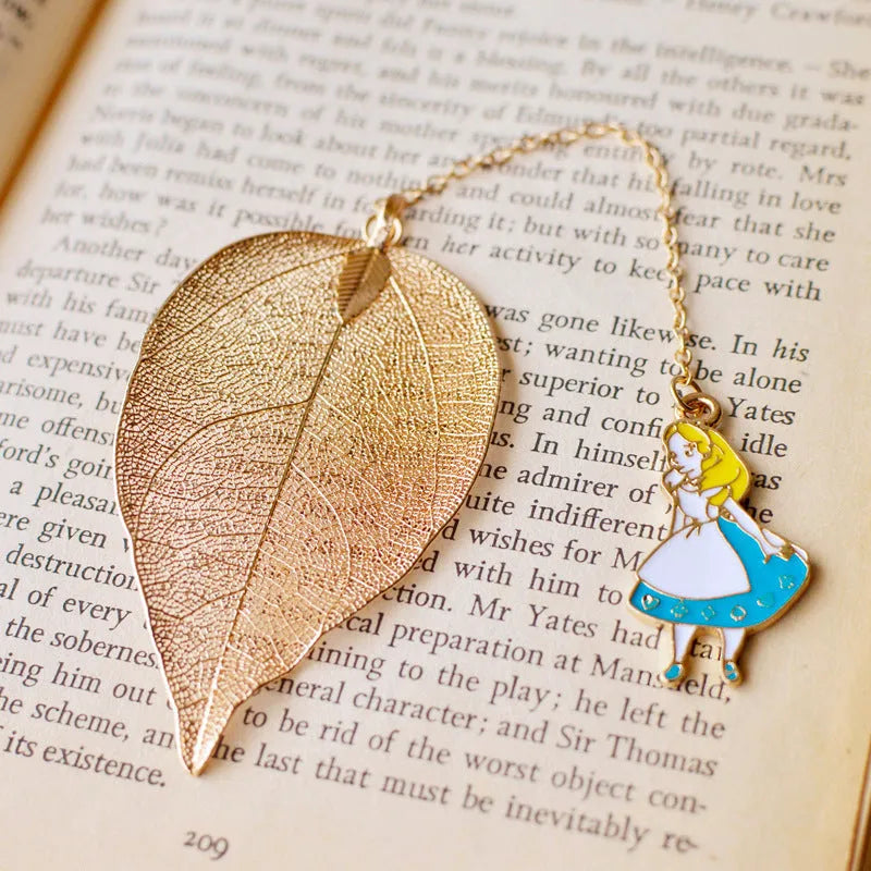 Set of three metal bookmarks featuring Alice, a rabbit, and a clock charm on a leaf base.