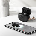 Pebble Series mini wireless Bluetooth earbuds and charging case in black, placed on a white surface.
