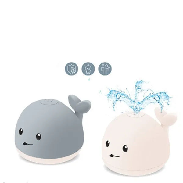Grey and white whale bath toy with water spray, LED lights, floating in water
