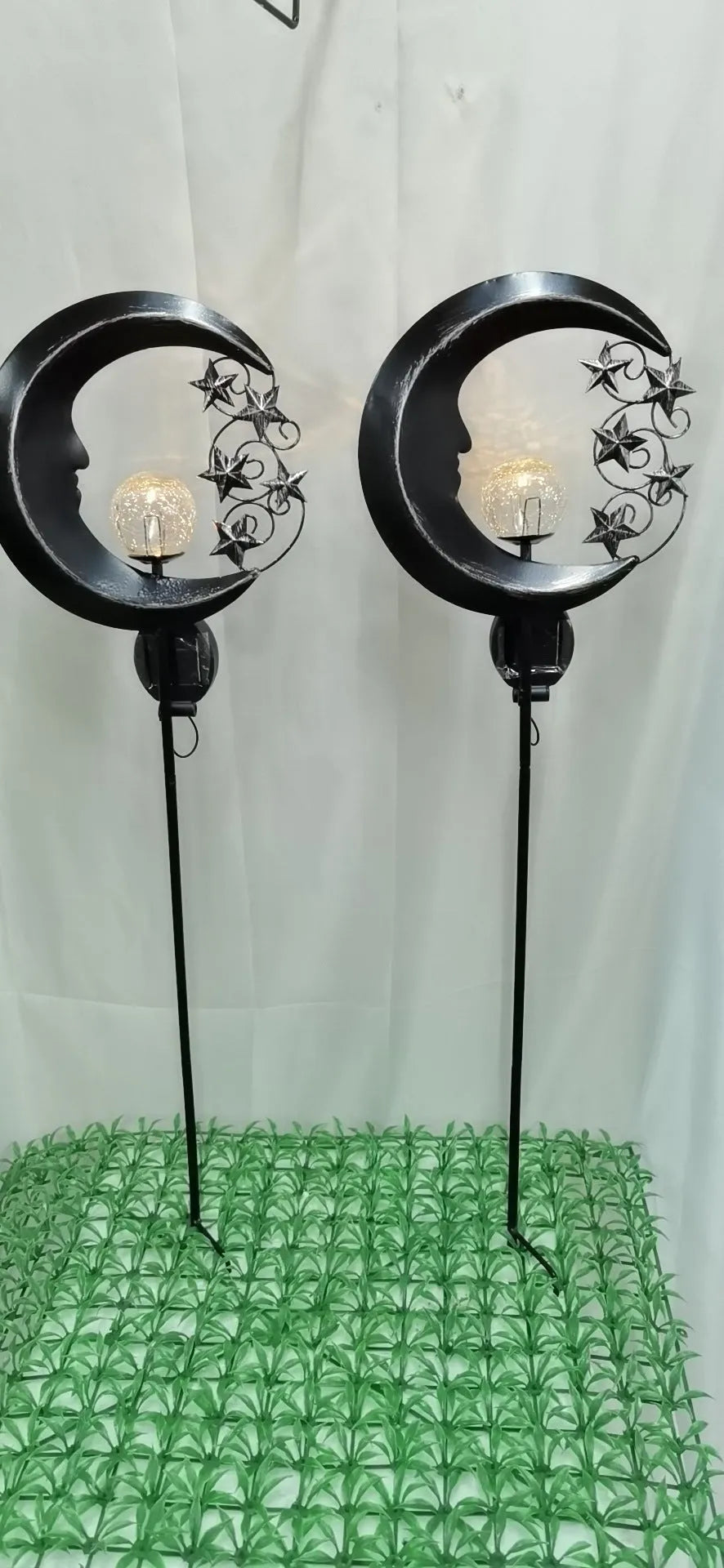 Blue moon and star design solar-powered wrought iron garden light with a glass ball.