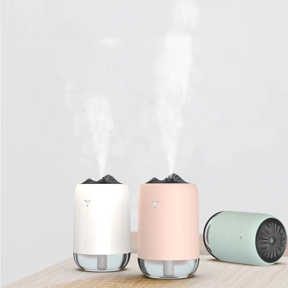 Magic Flame ultrasonic mini humidifier in white, blue, and pink colours on a desktop