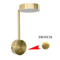 Gold LED wall lamp with rotary switch and acrylic shade on a wall