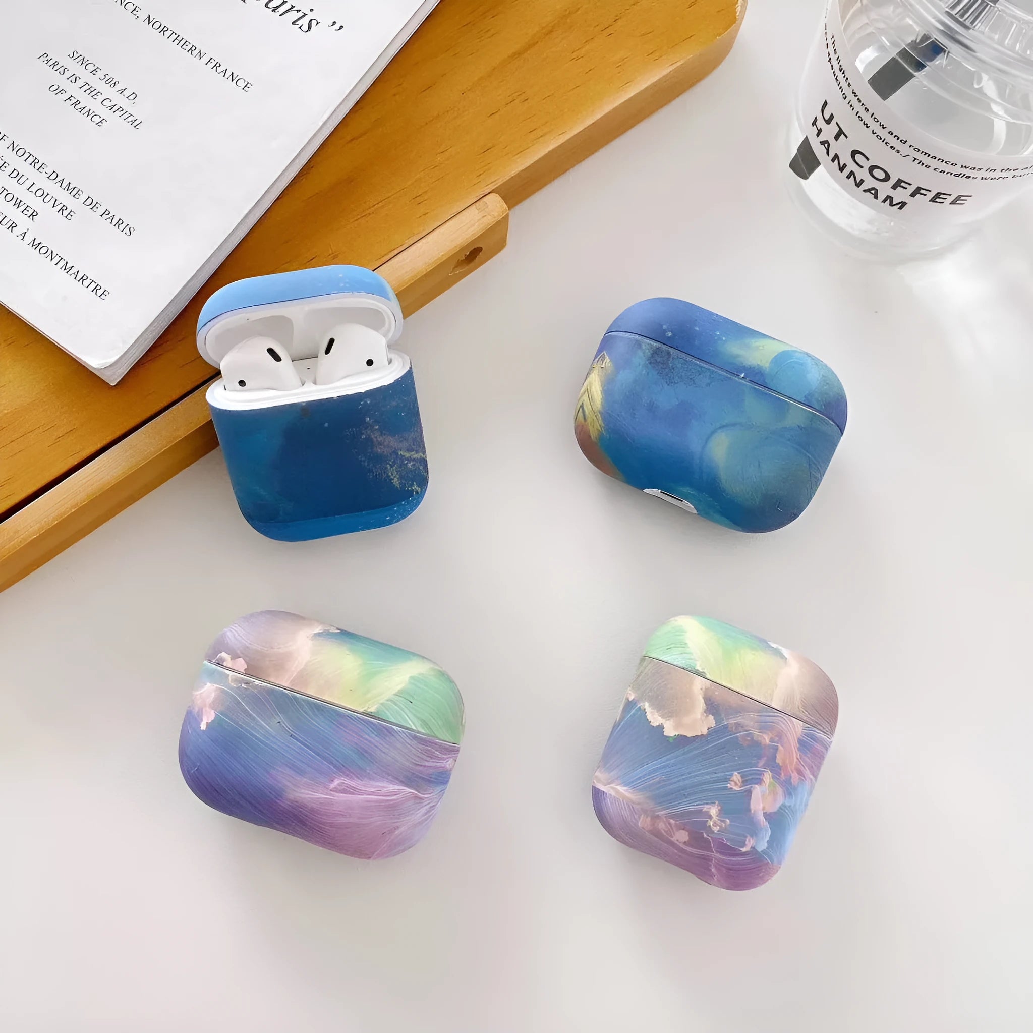 Hard plastic protective sleeve for Apple AirPods in pink and blue watercolour designs.