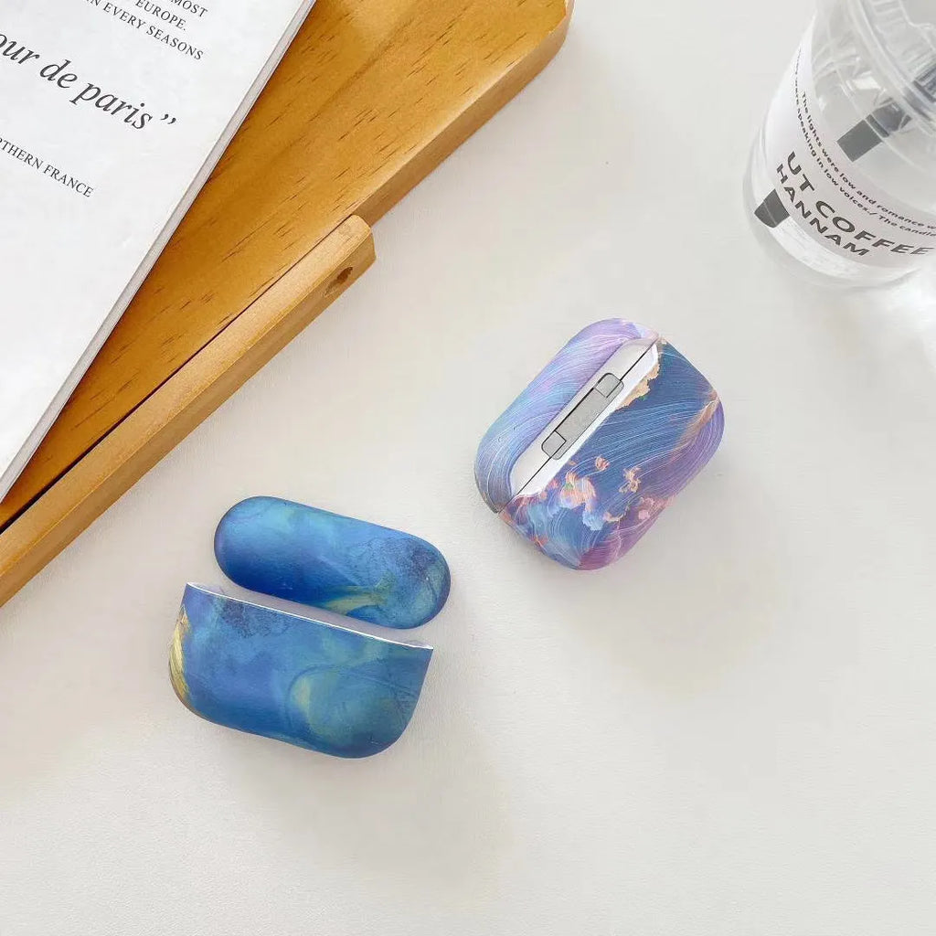 Hard plastic protective sleeve for Apple AirPods in pink and blue watercolour designs.