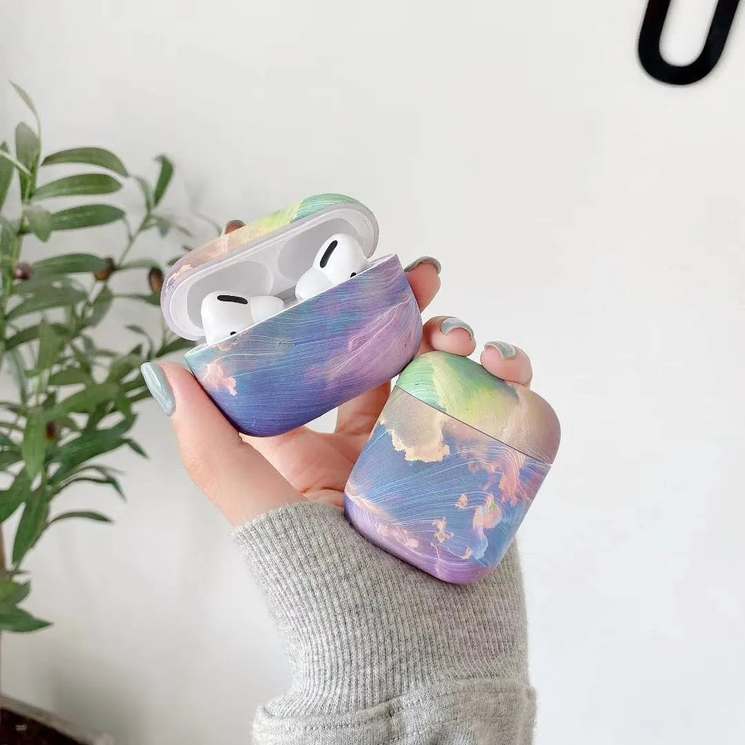 Hard plastic protective sleeve for Apple AirPods in pink and blue watercolour designs.