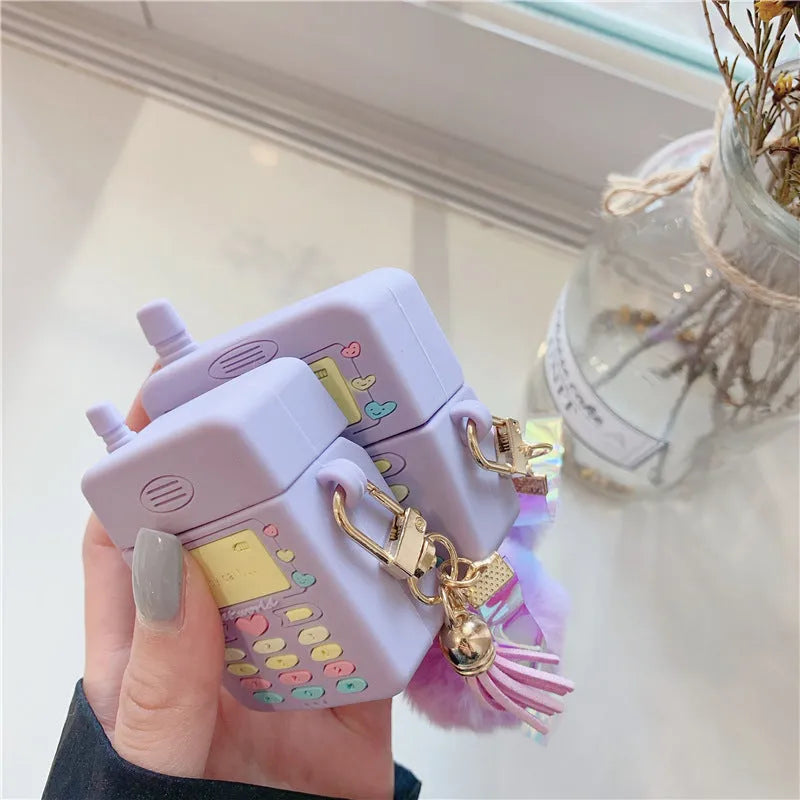Purple silicone protective case for Apple AirPods with a white fur ball pendant attached.