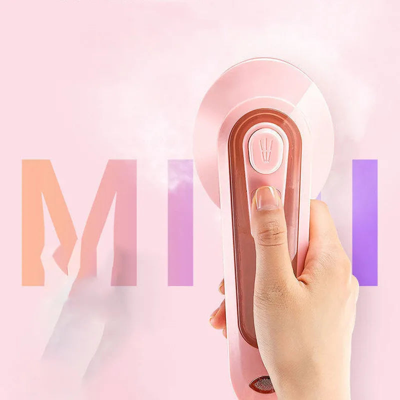 Pink portable electric iron with EU and US plug adapters on a white background