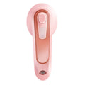 Pink portable electric iron with EU and US plug adapters on a white background