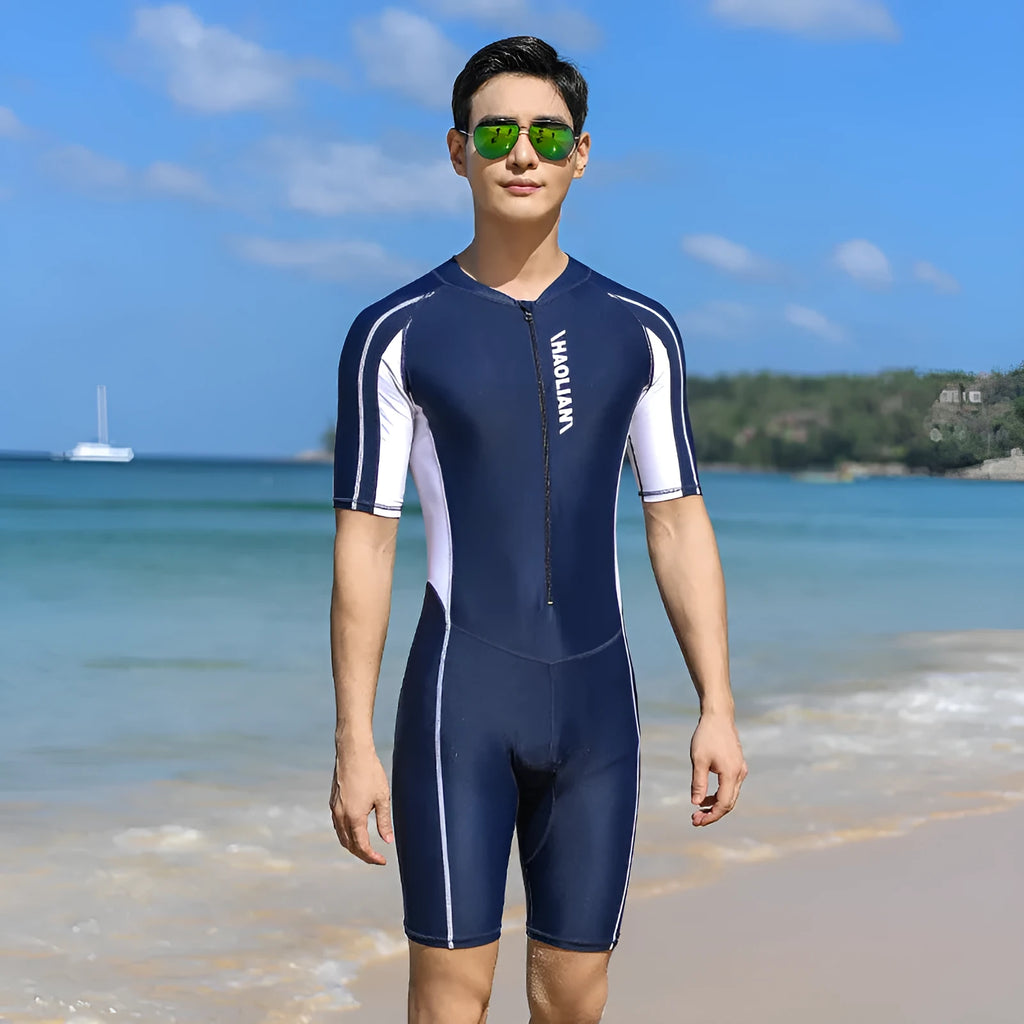 Men's short-sleeved neoprene surfing suit with front zip, in black, shown on a model.