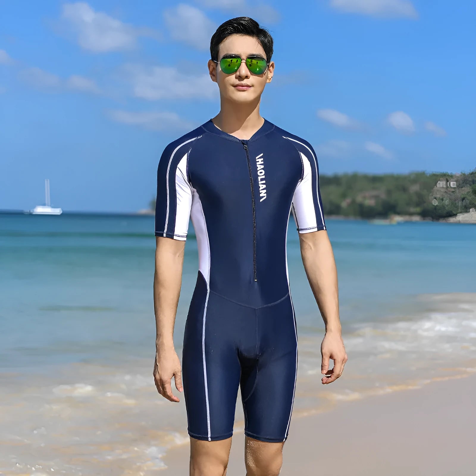 Men's short-sleeved neoprene surfing suit with front zip, in black, shown on a model.