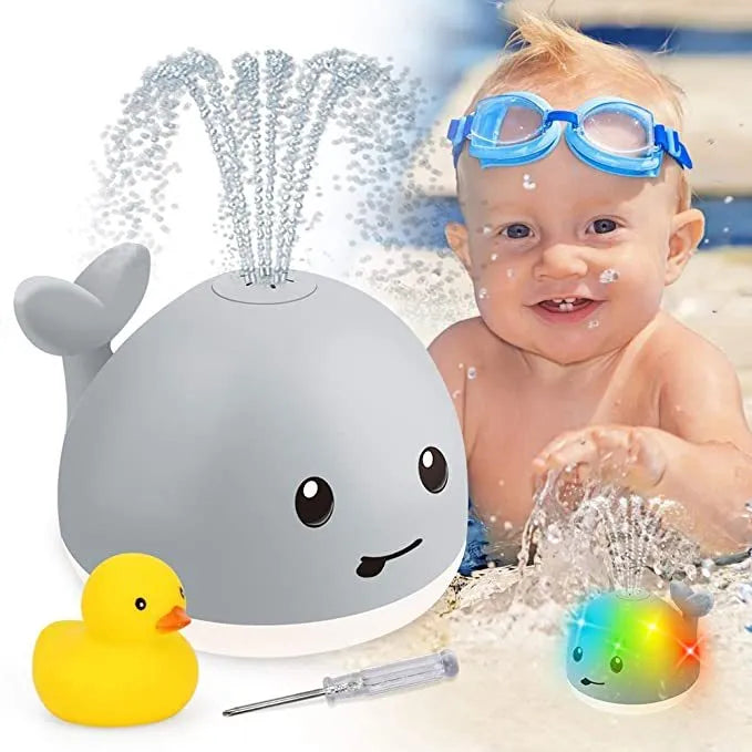 Grey and white whale bath toy with water spray, LED lights, floating in water