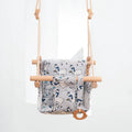Cotton canvas baby swing chair with wooden seat and cushion hanging indoors
