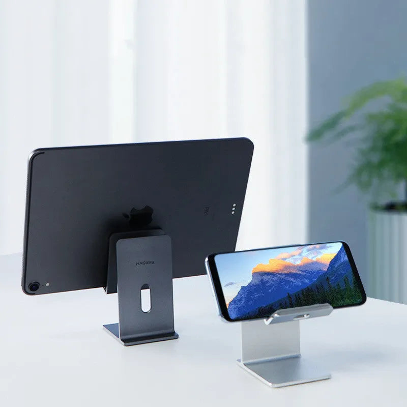Dark Space Gray alloy lazy bracket mobile phone and tablet holder on a desktop.