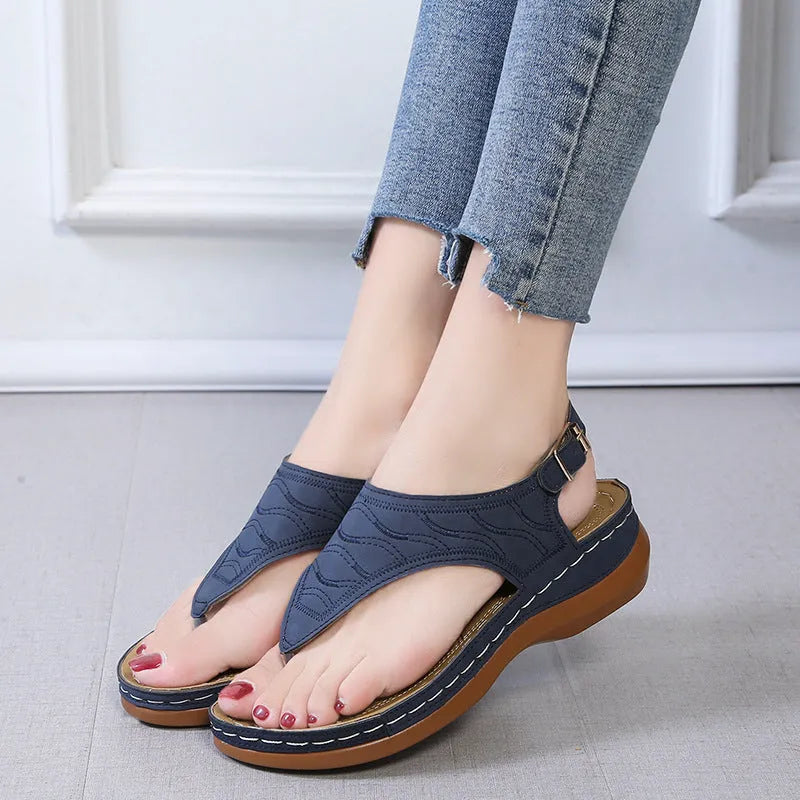 Women's red casual wedge heel sandals with an adjustable buckle strap on a white background.