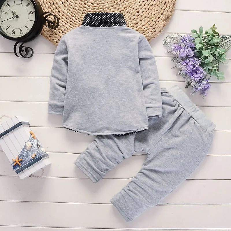 Toddler boy wearing a grey casual printed suit set with jacket and trousers.