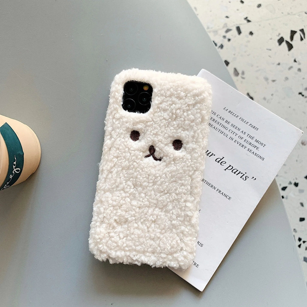 Brown embroidered plush cartoon bear face on a flexible TPU iPhone case.