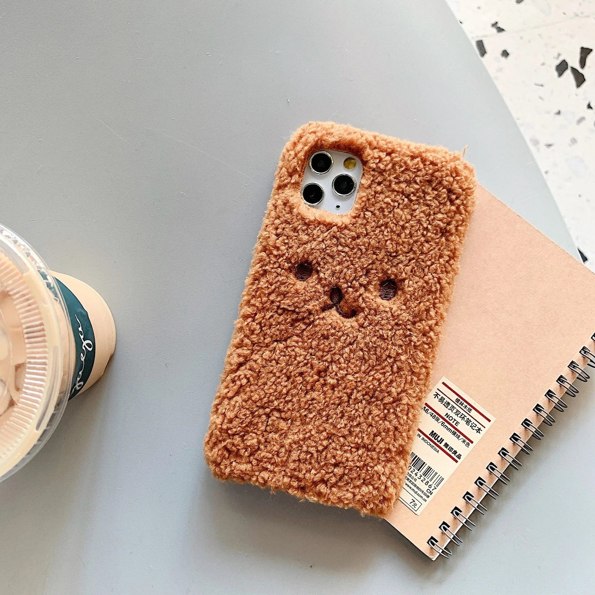Brown plush cartoon bear face embroidered on a soft TPU iPhone case for iPhone 11.