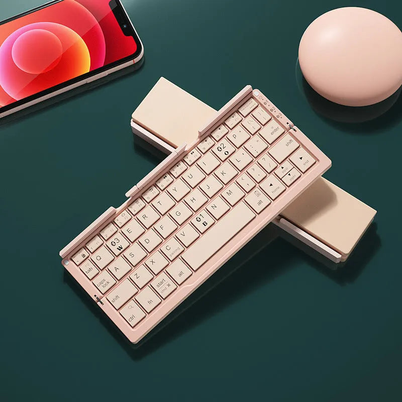 Silver and black grey foldable Bluetooth keyboard open with stand holding a mobile phone