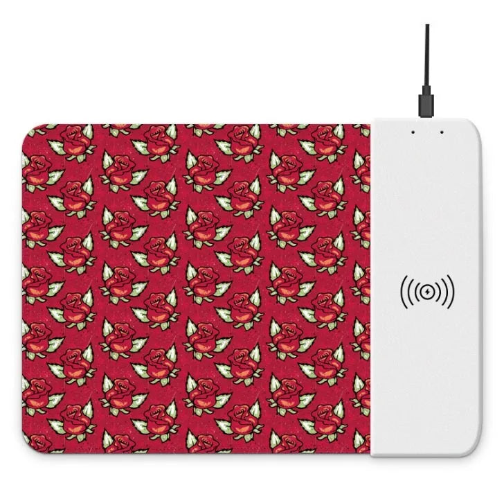 Black wireless charging mouse pad with RGB lighting edge and a cartoon design, shown on a desk.