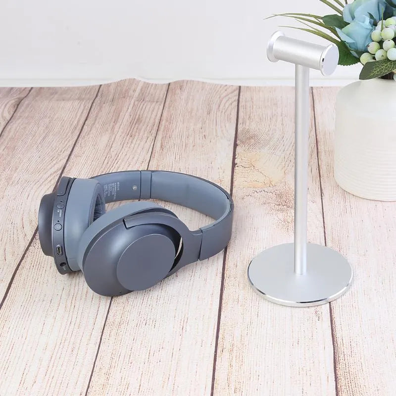 Black aluminium alloy headset bracket holding earphones on a desk