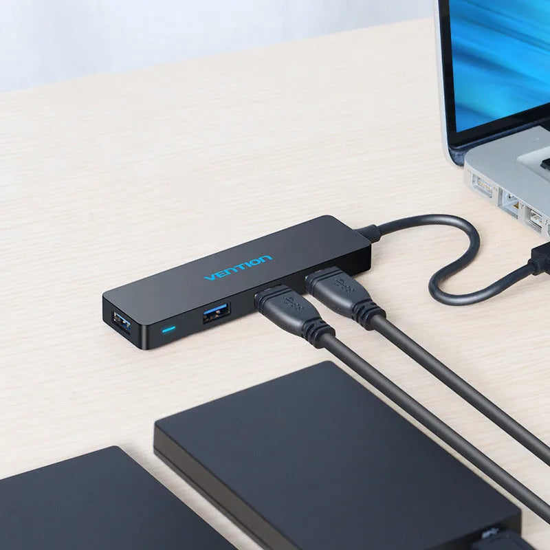 Black four-port USB 3.0 hub with a short 15cm cable on a desk