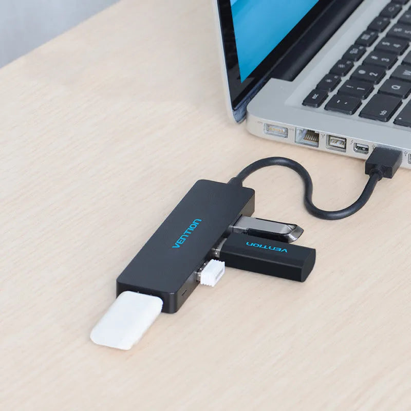 Black four-port USB 3.0 hub with a short 15cm cable on a desk