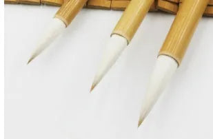 Three Chinese calligraphy brushes with bamboo handles and woolen bristles in large, medium, and small sizes