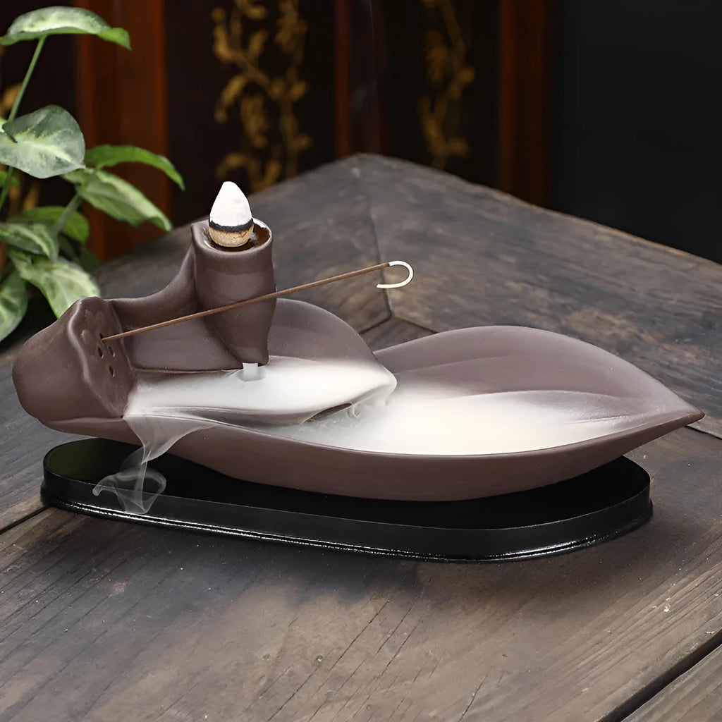 Brown purple sand backflow incense burner 8.5x21x9 cm on a wooden surface with smoke flowing downwards