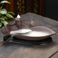 Brown purple sand backflow incense burner 8.5x21x9 cm on a wooden surface with smoke flowing downwards