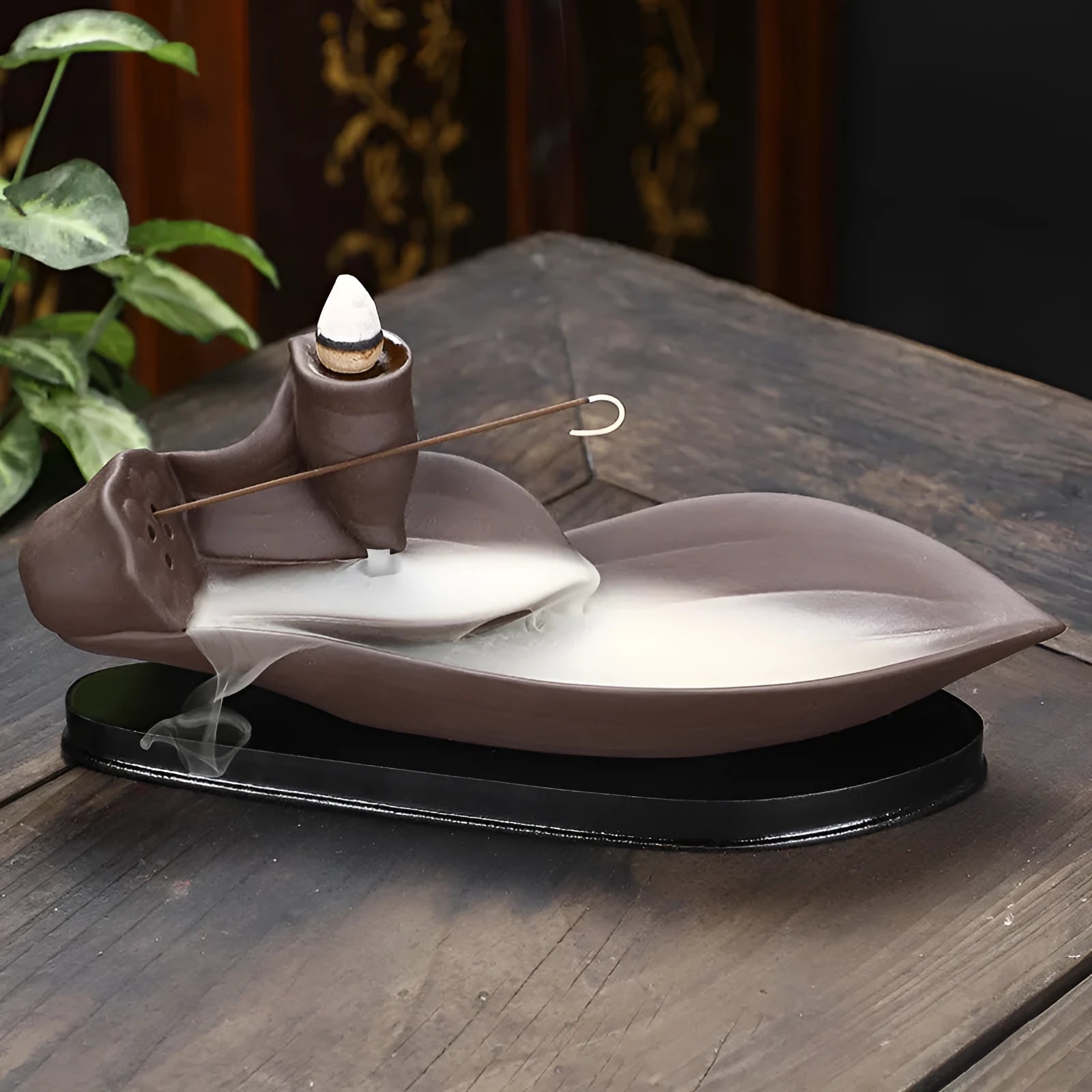 Brown purple sand backflow incense burner 8.5x21x9 cm on a wooden surface with smoke flowing downwards