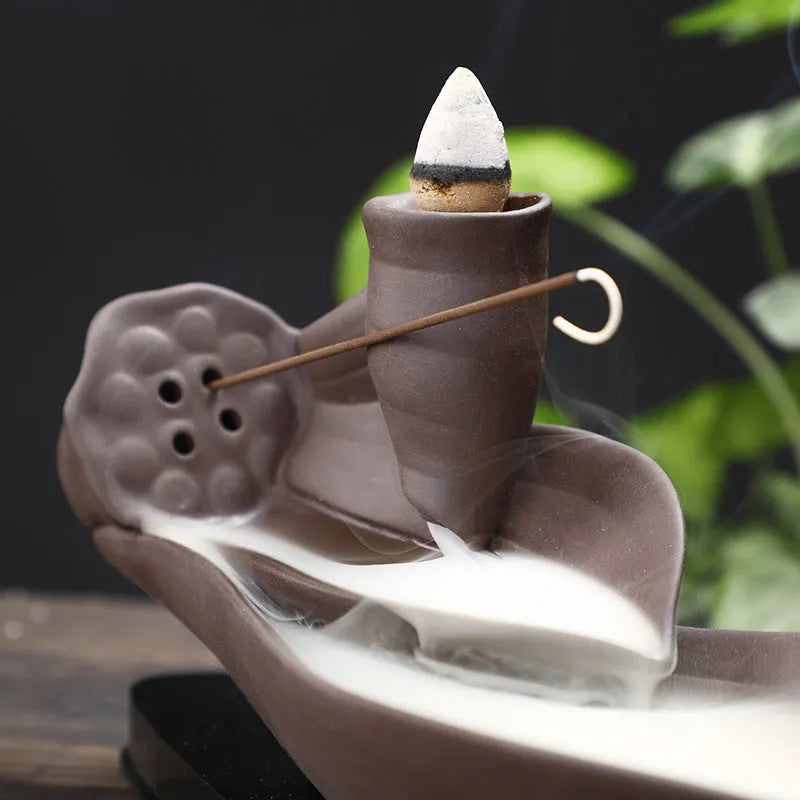 Brown purple sand backflow incense burner 8.5x21x9 cm on a wooden surface with smoke flowing downwards