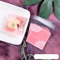 Pink self-adhesive plastic packaging bag with a 3cm header, shown sealing a bar of handmade soap.