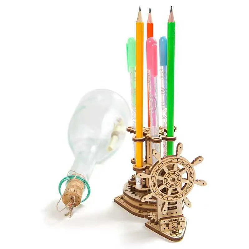 Ukrainian-style wooden rotating steering wheel pen holder model kit on a desk.