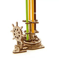Ukrainian-style wooden rotating steering wheel pen holder model kit on a desk.