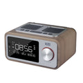 Wooden Bluetooth speaker alarm clock radio in golden oil colour on a bedside table.