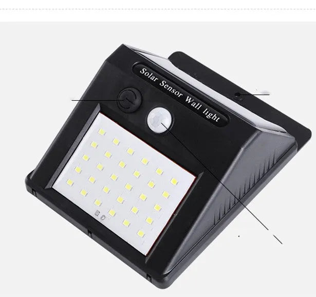 A white solar-powered garden lamp with LED lights and a solar panel on top, standing in a garden.