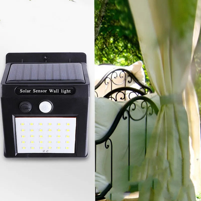 A white solar-powered garden lamp with LED lights and a solar panel on top, standing in a garden.