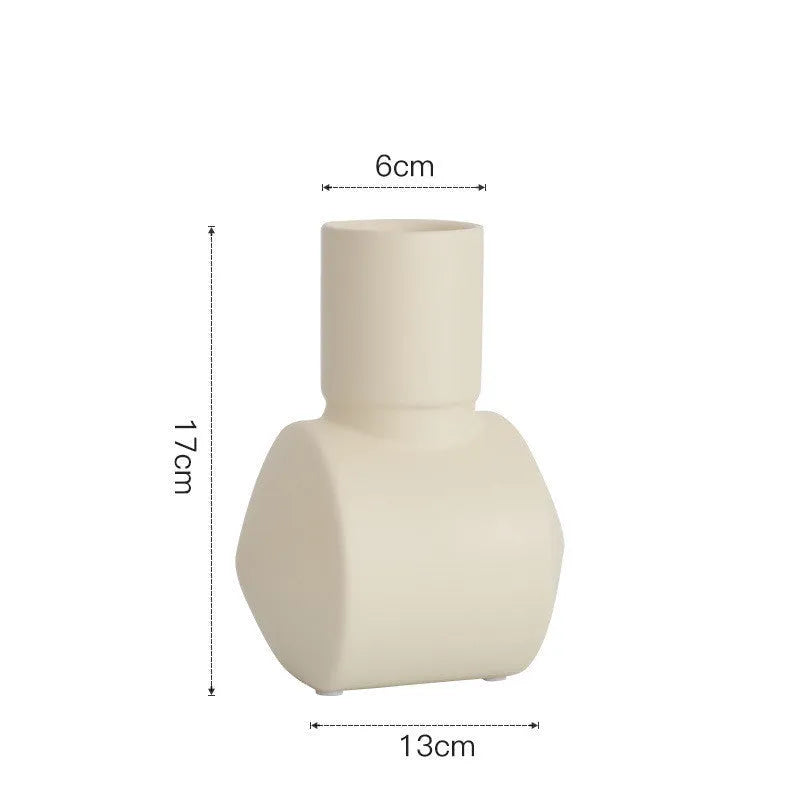 A simple hammer-textured ceramic vase in a Morandi colour on a wooden surface.