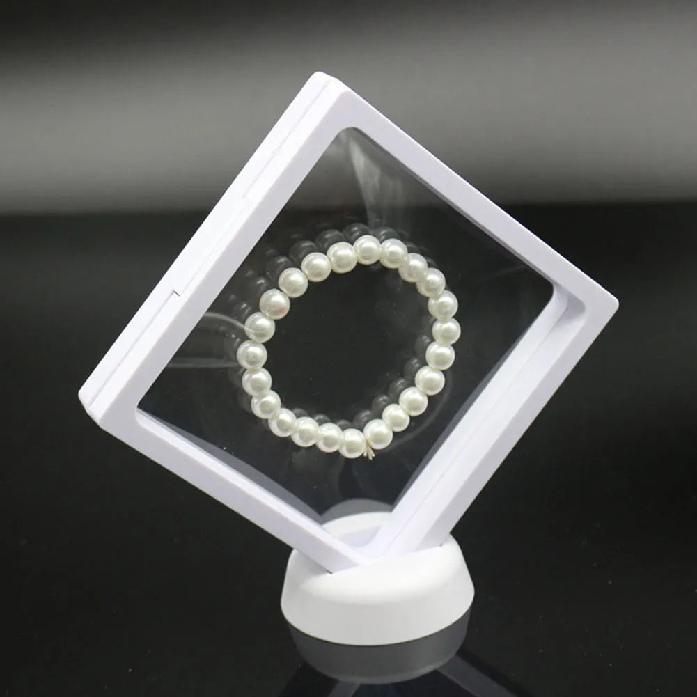 3D floating display case holding coins and jewellery between transparent membrane sheets
