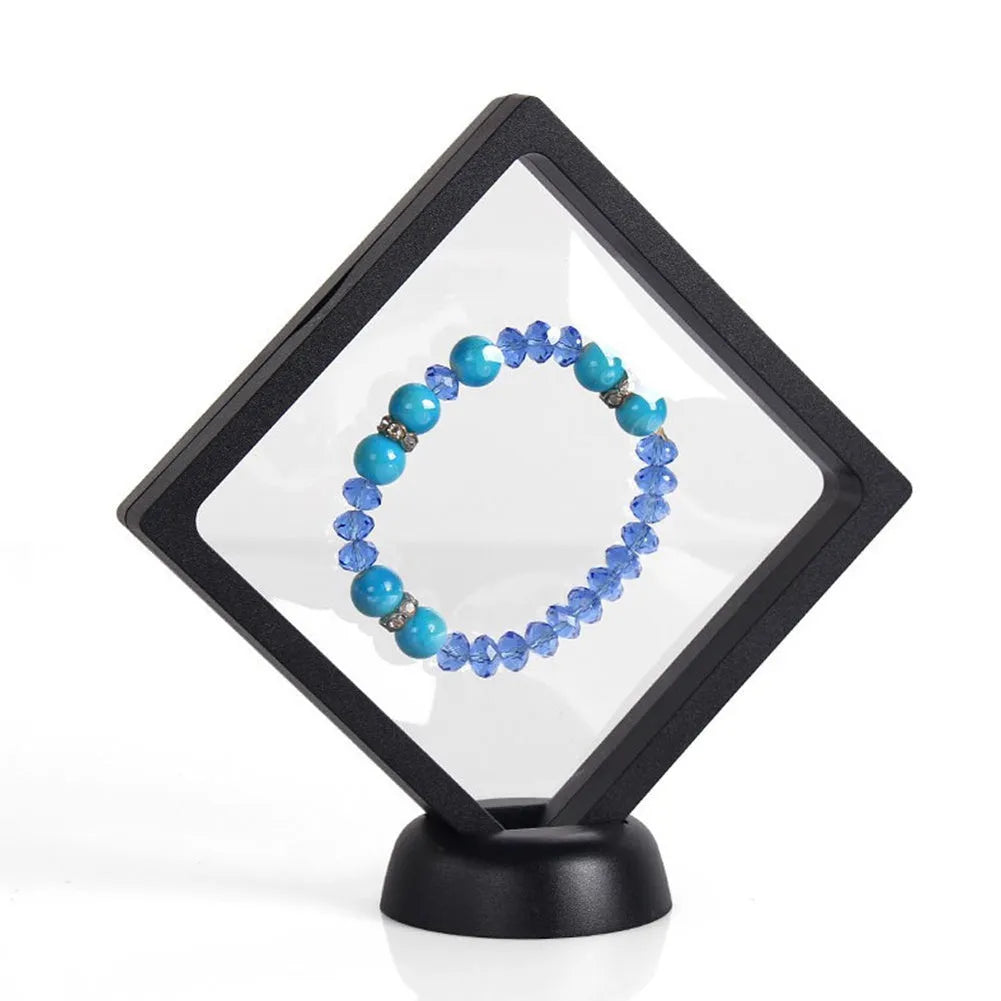 3D floating display case holding coins and jewellery between transparent membrane sheets