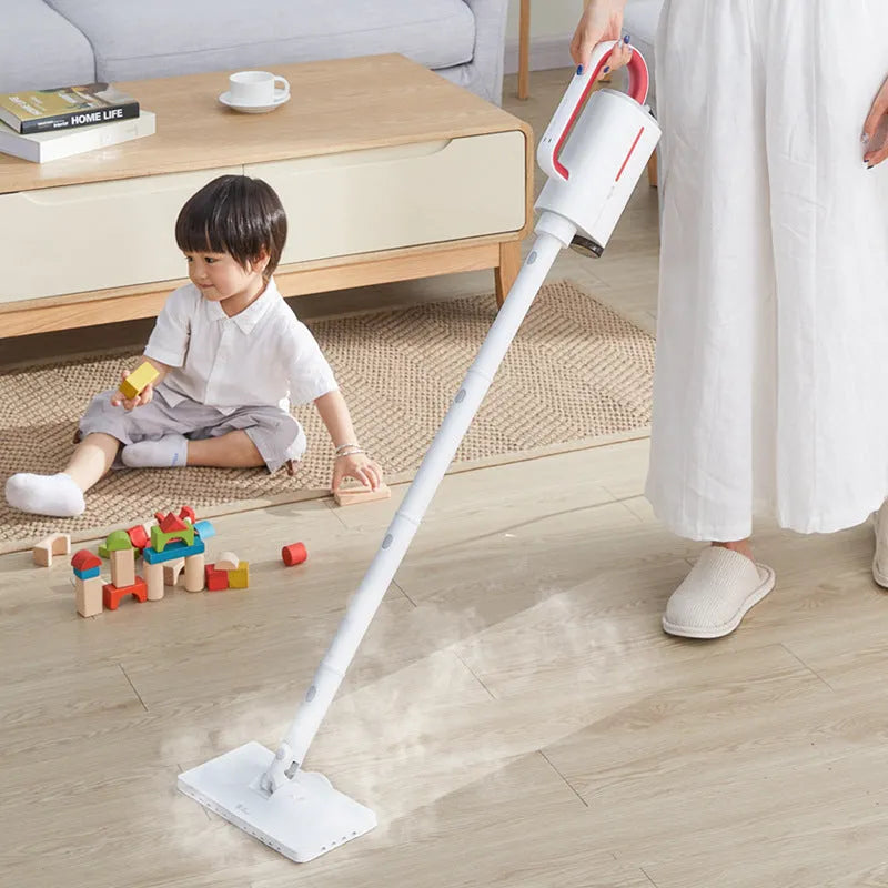Deerma DEM-ZQ610 white steam cleaner with brush heads and glass scraper on a grey surface