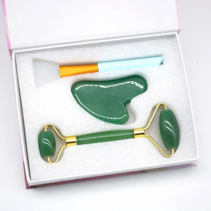Aventurine face roller with opal heart design on a flat surface