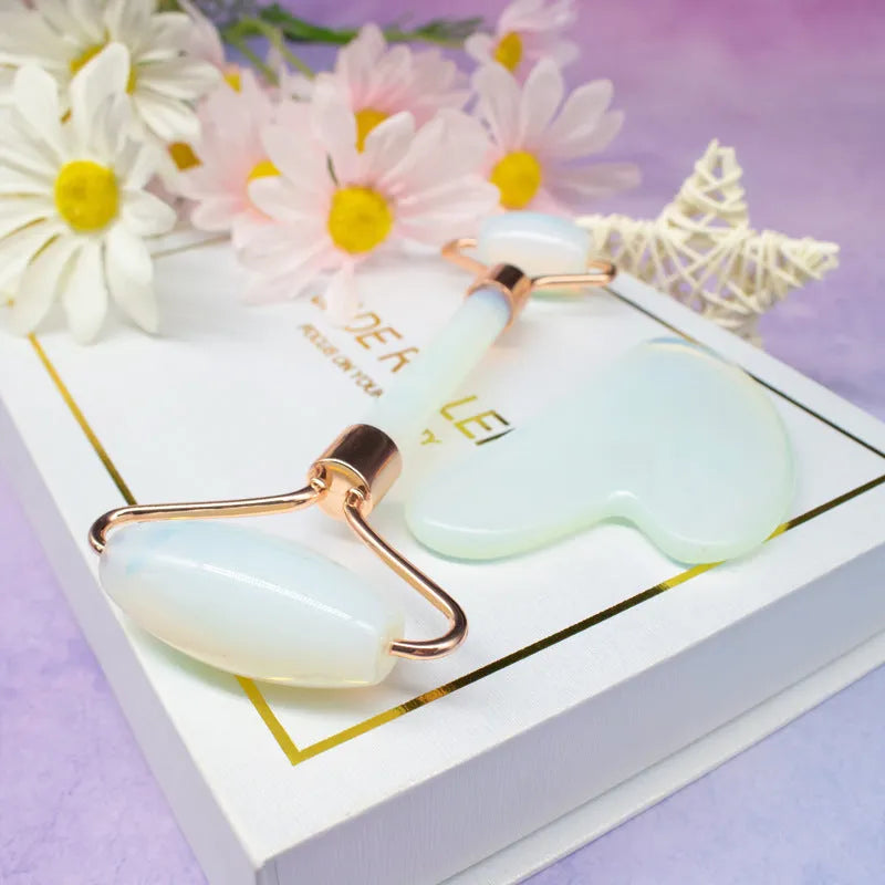Aventurine face roller with opal heart design on a flat surface