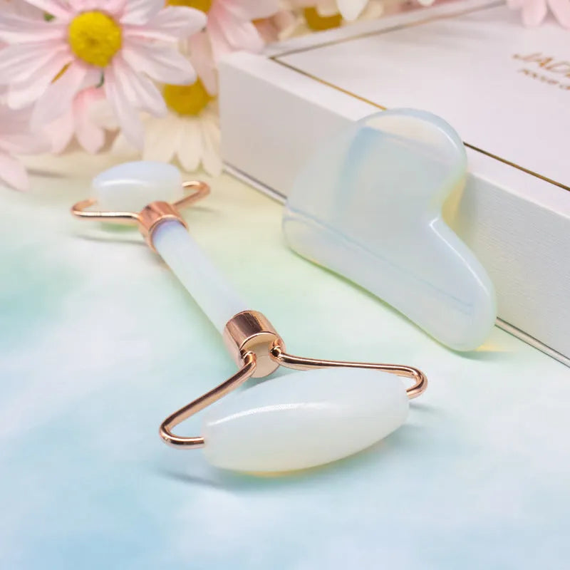 Aventurine face roller with opal heart design on a flat surface
